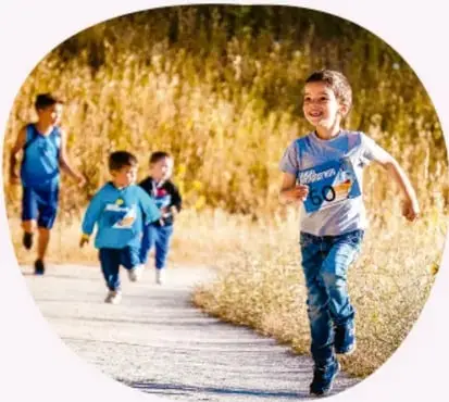 Fotografía circular de tres niños corriendo por un camino de campo, ilustrando el movimiento.