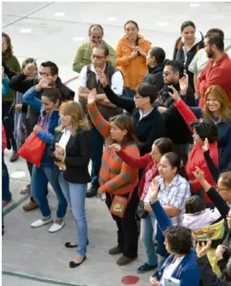 Cuatro personas trabajando con materiales y documentos sobre una mesa en una sesión colaborativa.