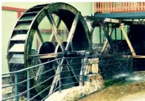 Fotografía de un captador de agua de lluvia casero con un paraguas viejo dentro de un recipiente.
