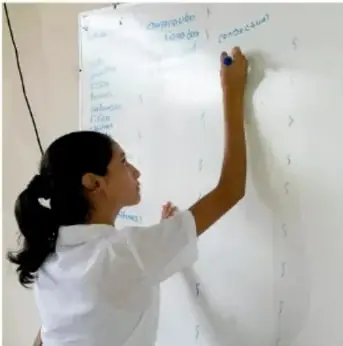 Fotografía de una estudiante escribiendo con plumón en un papelógrafo durante una sesión de trabajo; crédito: Jesús Eduardo Arteaga Flores, Tamaulipas.