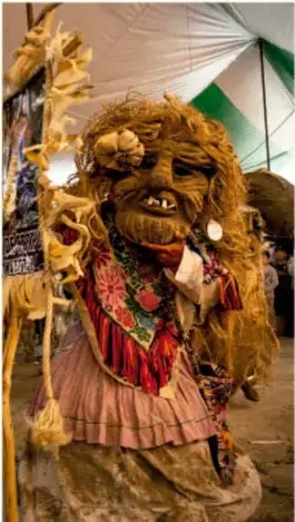 Fotografía de una persona con máscara y atuendo tradicional de la danza de los viejitos, con textil bordado y sombrero, en un entorno de fiesta. Crédito: Sandra Angélica Martínez Cruz, Baja California.