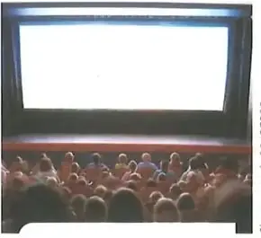 Personas observan una película en una sala de cine.