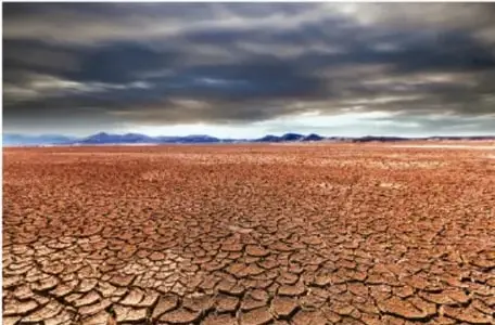 Desierto con suelo agrietado y seco bajo un cielo nublado, representando un ambiente inanimado.