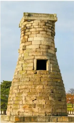 Fotografía del antiguo observatorio de Cheomseongdae en Gyeongju, Corea del Sur: torre de piedra con forma cilíndrica sobre base ancha.