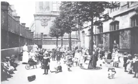 Fotografía histórica en blanco y negro de una calle de París con numerosas personas, entre ellas mujeres y niños, durante el periodo de la Comuna.