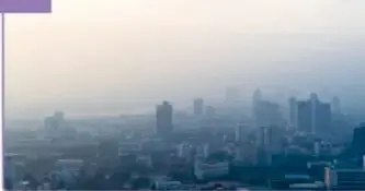 Ciudad con esmog o neblina contaminante sobre edificios.