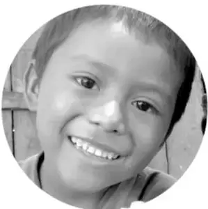 Fotografía circular en escala de grises de una niña sonriente, probablemente ilustrando a un estudiante de primaria.
