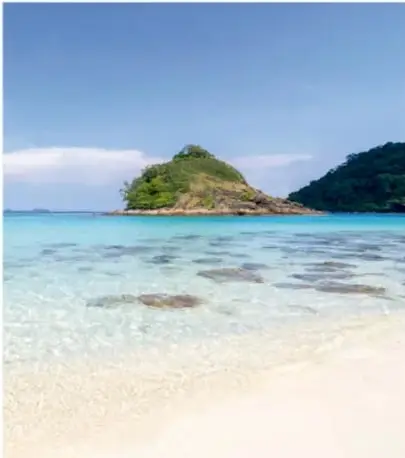 Fotografía de una playa tropical con agua cristalina y una isleta, ilustrando el escenario del campamento.