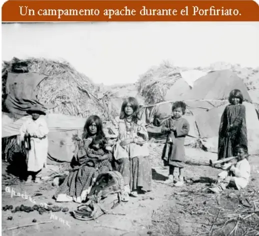 Fotografía de un grupo de indígenas nómadas, hombres, mujeres y niños, posando al aire libre.