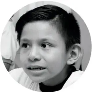 Fotografía en blanco y negro de un niño con expresión pensativa.