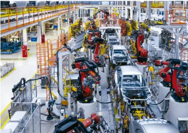 Planta industrial con robots automatizados ensamblando automóviles en una línea de producción.
