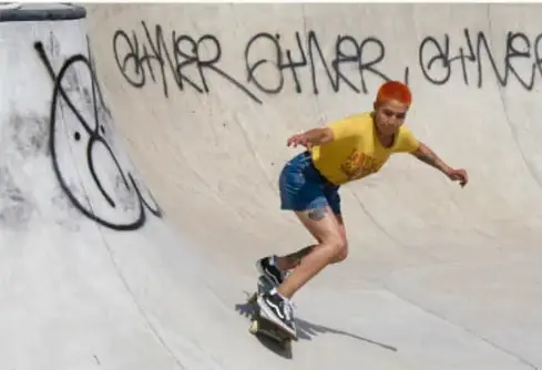 Fotografía de un joven patinando en un bowl de concreto con grafiti, ilustrando el uso de espacios comunitarios.