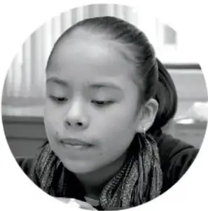 Fotografía de una niña con cabello recogido, mirando hacia abajo.