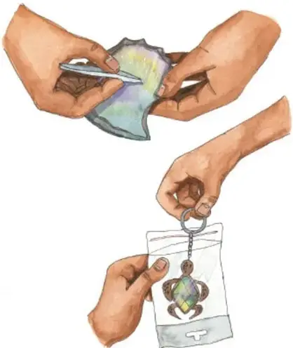 Manos recortando material reciclado con tijeras.