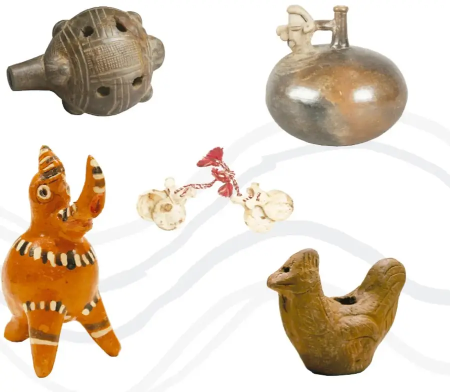 Silbato u ocarina esférica de barro oscuro con orificios y boquilla tubular.
