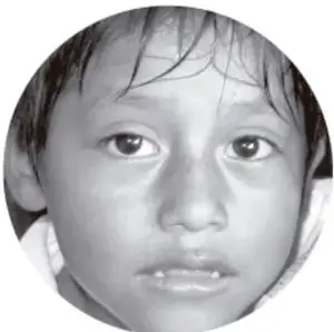 Fotografía circular en blanco y negro del rostro de una niña que mira hacia el frente.