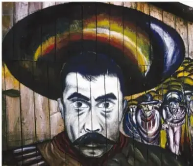 Mural con la figura de Emiliano Zapata con sombrero, acompañado de otras personas, en tonos oscuros y amarillos.