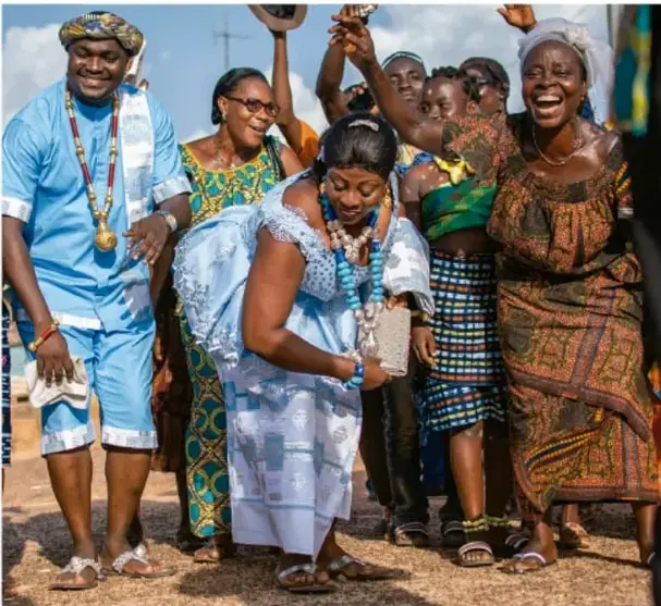 Fotografía de un grupo de personas de distintas edades celebrando alegremente con vestimenta tradicional colorida, ilustrando la cohesión y el sentido de pertenencia comunitario.
