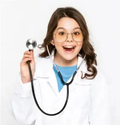 Fotografía de una niña con bata blanca de doctora y estetoscopio, sonriendo.