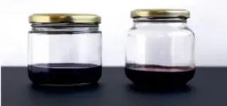 Dos frascos de vidrio con tapa metálica conteniendo líquido oscuro, probablemente los indicadores preparados.