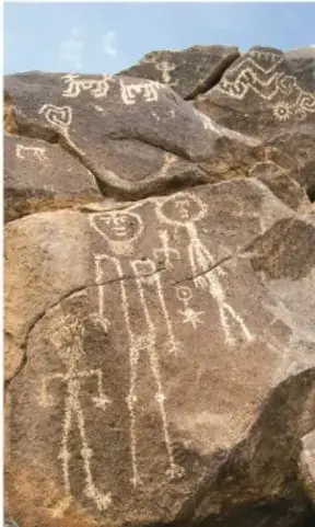 Petróglifos tallados en una roca: figuras humanas estilizadas, espirales y símbolos, propios del arte rupestre del suroeste de Norteamérica.