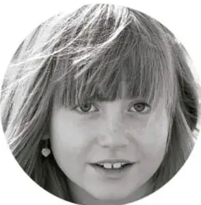 Fotografía circular en blanco y negro del rostro sonriente de una niña con flequillo, como ejemplo de participante del proyecto.