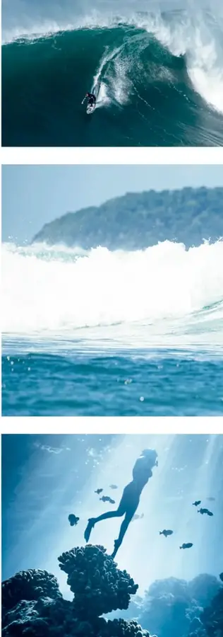 Ola rompiendo con mucha espuma blanca sobre el mar azul, con una montaña o colina al fondo.