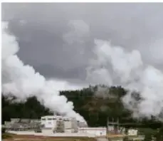 Planta geotermoeléctrica emitiendo columnas de vapor blanco, representando el aprovechamiento del calor interno de la Tierra.