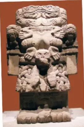 Escultura prehispánica de piedra, probablemente Coatlicue, con falda de serpientes y rasgos antropomorfos.