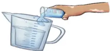 Mano que vierte agua desde un vaso graduado dentro de un recipiente de plástico.
