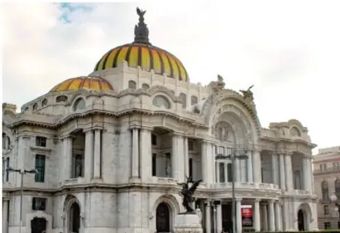 Fotografía de un gran edificio de arquitectura porfirista con cúpula y columnas, posiblemente el Palacio de Bellas Artes o el Palacio de Correos de México.