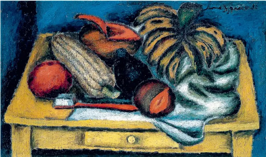 Pintura al óleo Naturaleza muerta de María Izquierdo: sobre una mesa amarilla con cajón se observan una rebanada de sandía, un plátano, un mamey, una tuna roja, una calabaza o chilacayote, un tejido blanco y un cuchillo y cuchara. El fondo es azul oscuro.