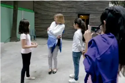 Grupo de niños en la calle con una cámara y equipo de grabación.
