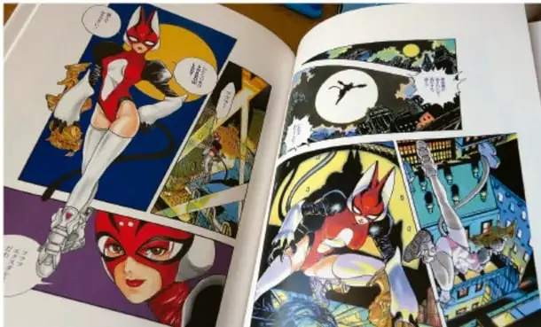 Fotografía de un cómic o manga abierto que muestra viñetas con personajes de estilo superheroico y sobrenatural en colores vivos.