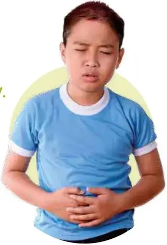 Niño con polera azul tocándose el estómago, con expresión de sentirse mal.