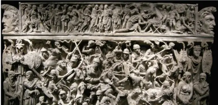 Relieve romano en piedra que representa una escena de batalla o conquista, con soldados y figuras en combate.