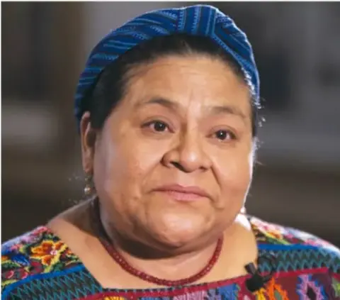 Retrato de Rigoberta Menchú con traje tradicional maya y tocado azul.
