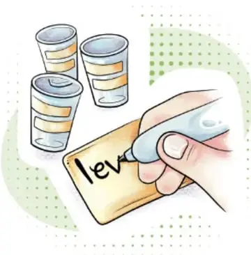 Mano escribiendo 'lev' en una etiqueta adhesiva, con tres vasos etiquetados al fondo. Crédito: Lavinia Cabrera Sandoval, TABASCO.