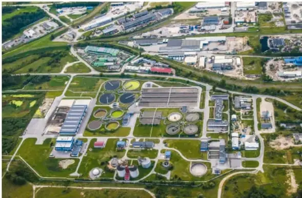 Vista aérea de una planta industrial de tratamiento de agua con tanques circulares y edificaciones, ilustrando procesos a gran escala de separación.