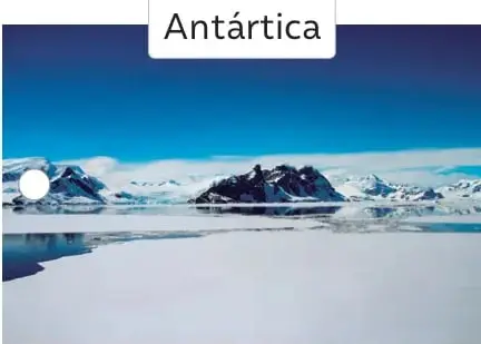 Paisaje antártico: mar helado, icebergs y montañas nevadas bajo cielo azul. Rótulo «Antártica».