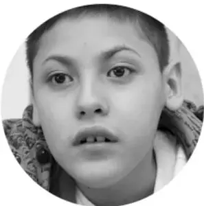 Fotografía en blanco y negro de un estudiante de primaria con expresión pensativa.