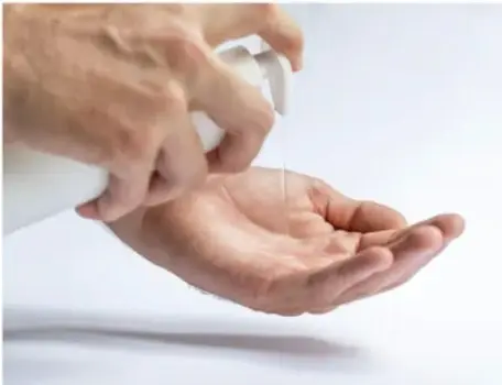 Fotografía de dos manos aplicándose gel antibacterial de un dispensador.