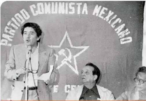 Fotografía en blanco y negro de Arnoldo Martínez Verdugo hablando ante un micrófono, con el logotipo del Partido Comunista Mexicano al fondo; al lado, Valentín Campa.