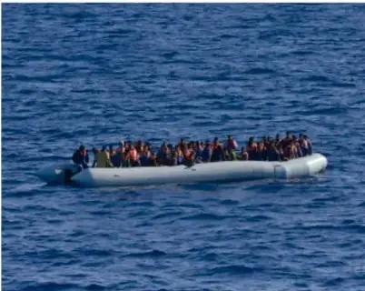 Personas migrantes en una embarcación improvisada en el mar, representando la migración hacia Europa.