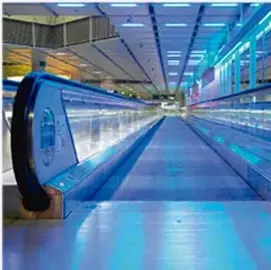 Pasillo con cinta transportadora/escalera eléctrica en un centro comercial, ilustrando energía mecánica en movimiento.