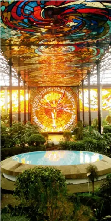 Cúpula de vidrio espacial de colorido arte abstracto (Jardín de los Artes) con estanque y vegetación, ilustrando manifestaciones artísticas.
