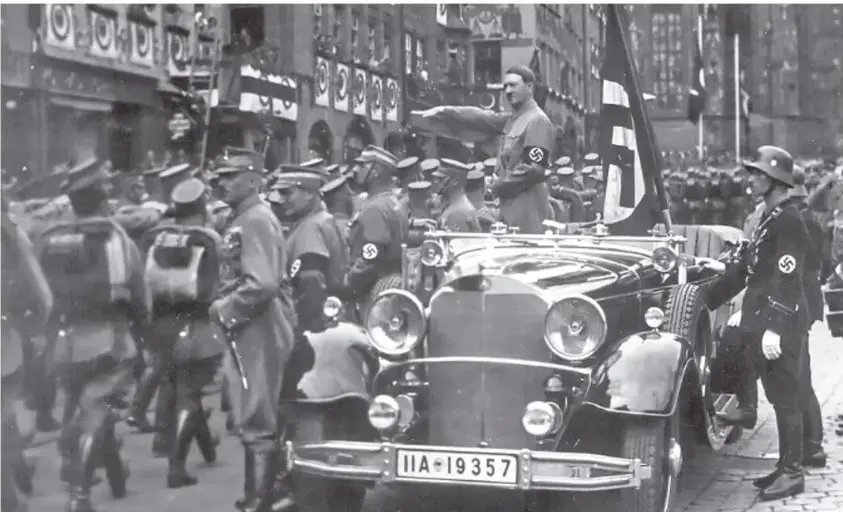 Desfile militar nazi con vehículos, tropas y esvásticas en un entorno urbano.