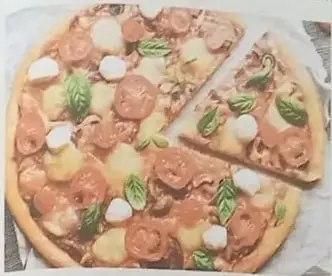 Fotografía de una pizza con tomates cherry, mozzarella y albahaca.
