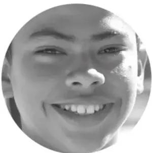 Fotografía en blanco y negro del rostro sonriente de un estudiante.