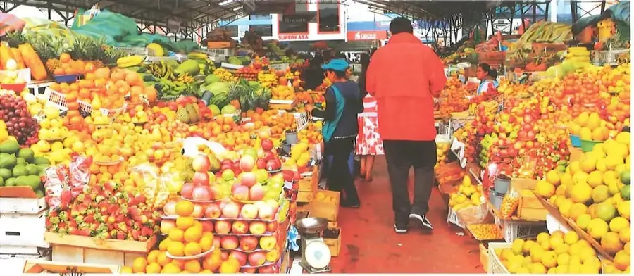 Fotografía de un mercado ecuatoriano con puestos que ofrecen frutas, verduras y otros alimentos frescos.
